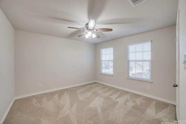 spare room with ceiling fan and light colored carpet