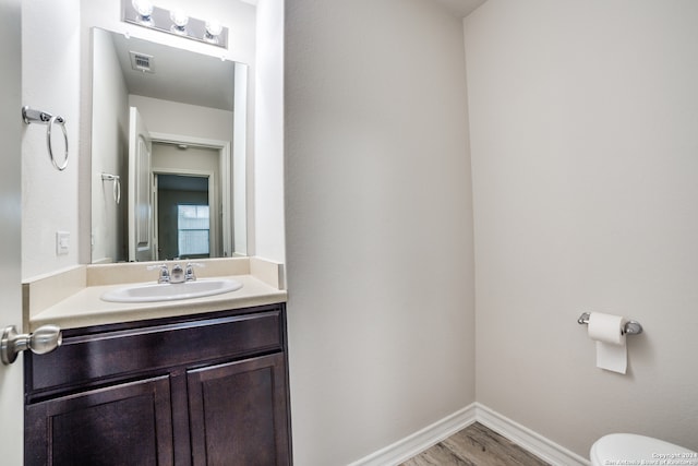 bathroom with vanity, hardwood / wood-style flooring, and toilet