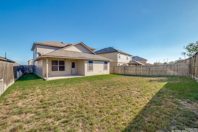 back of property featuring a patio area and a lawn