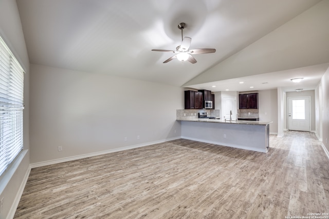 unfurnished living room with ceiling fan, sink, high vaulted ceiling, and light wood-type flooring