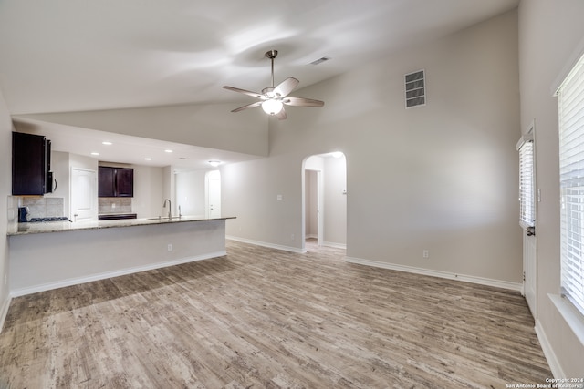 unfurnished living room featuring ceiling fan, sink, high vaulted ceiling, and light hardwood / wood-style floors