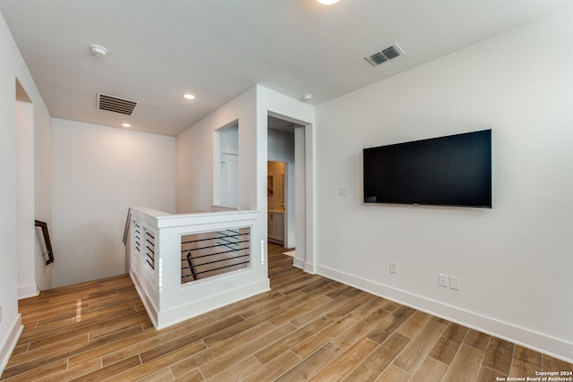 unfurnished living room with a textured ceiling and hardwood / wood-style flooring