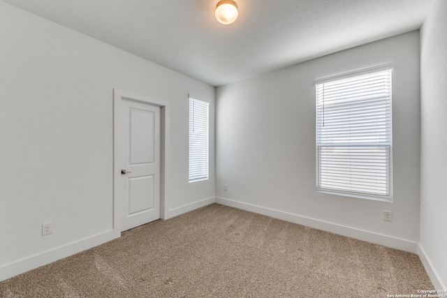 carpeted spare room featuring a healthy amount of sunlight