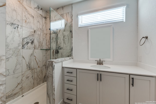 bathroom featuring a tile shower and vanity