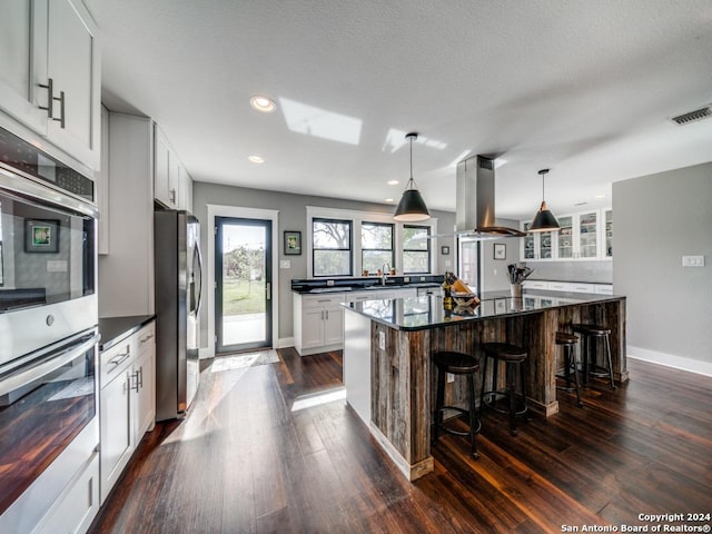 kitchen with white cabinets, a large island, and appliances with stainless steel finishes