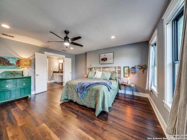 bedroom with multiple windows, hardwood / wood-style flooring, ensuite bath, and ceiling fan