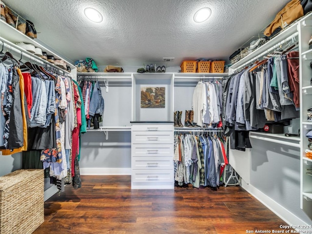 walk in closet with dark wood-type flooring