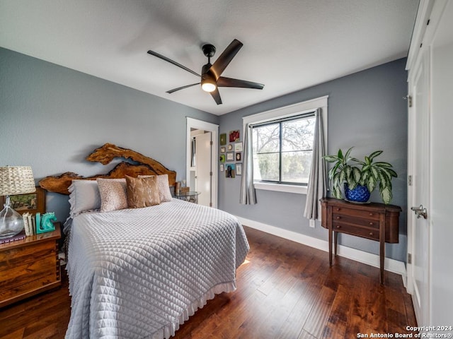 bedroom with dark hardwood / wood-style flooring and ceiling fan