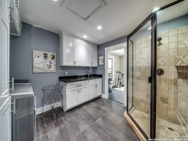 kitchen featuring white cabinets, separate washer and dryer, and sink