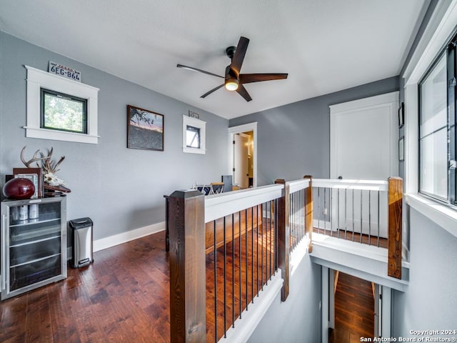 hall featuring dark wood-type flooring, beverage cooler, and a healthy amount of sunlight