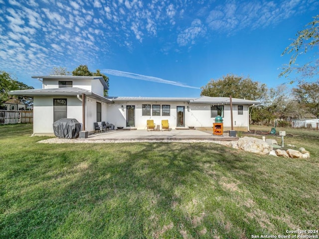 back of property featuring a lawn and a patio