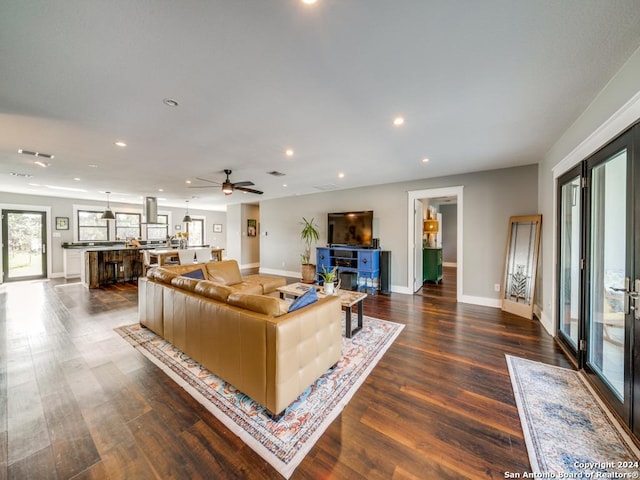 living room with dark hardwood / wood-style floors and ceiling fan