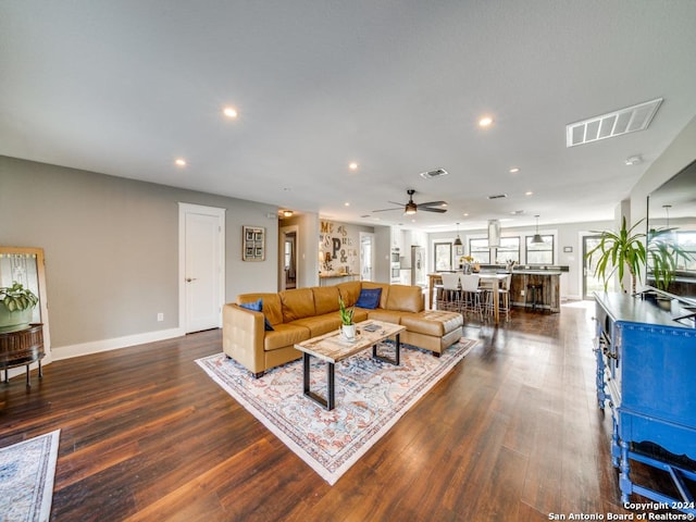 living room featuring ceiling fan and dark hardwood / wood-style flooring