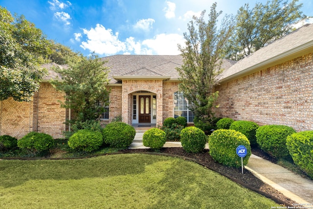 view of exterior entry with a yard