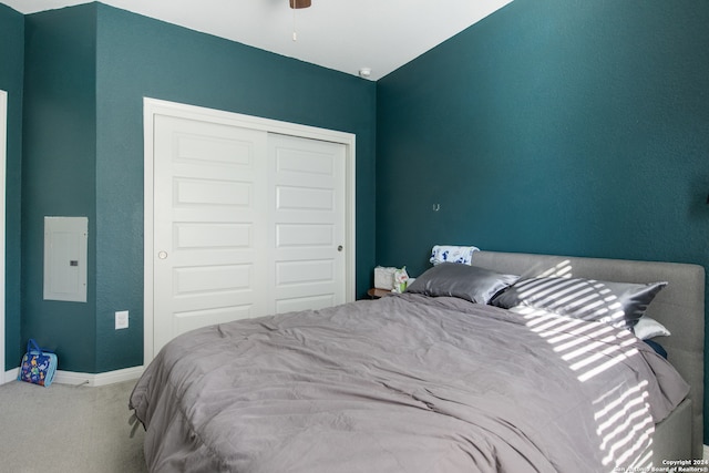 carpeted bedroom featuring electric panel, a closet, and lofted ceiling