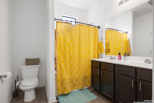 bathroom featuring vanity, hardwood / wood-style flooring, toilet, and curtained shower