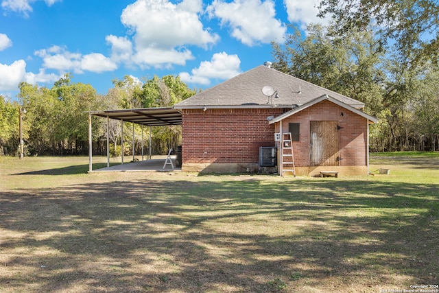 view of home's exterior with a carport, a lawn, and central AC