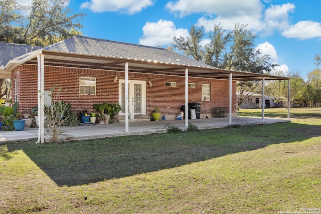 rear view of house with a lawn and a patio