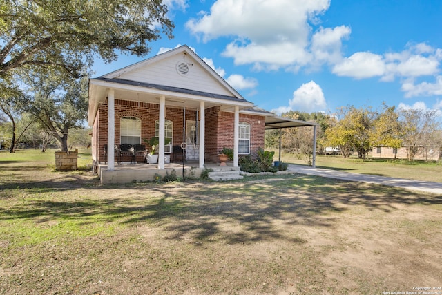 view of front of house featuring a carport, a porch, and a front lawn