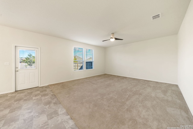 spare room with ceiling fan and light carpet