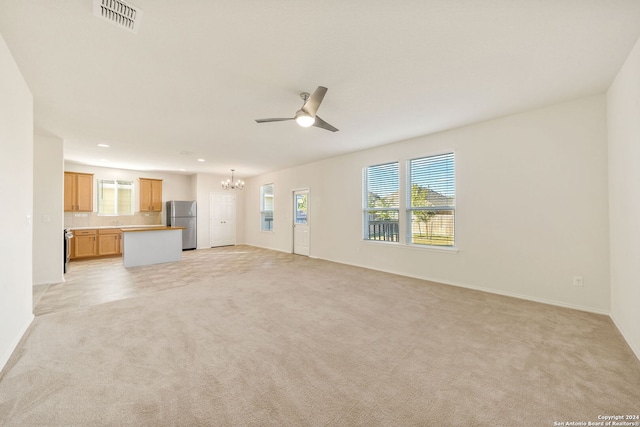 unfurnished living room featuring light colored carpet and ceiling fan with notable chandelier