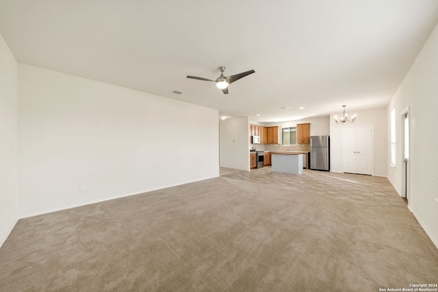 unfurnished living room with ceiling fan with notable chandelier and light carpet