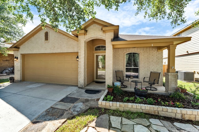 view of front of property with covered porch, a garage, and central air condition unit