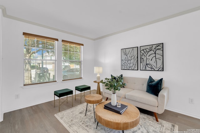 sitting room with hardwood / wood-style flooring and crown molding