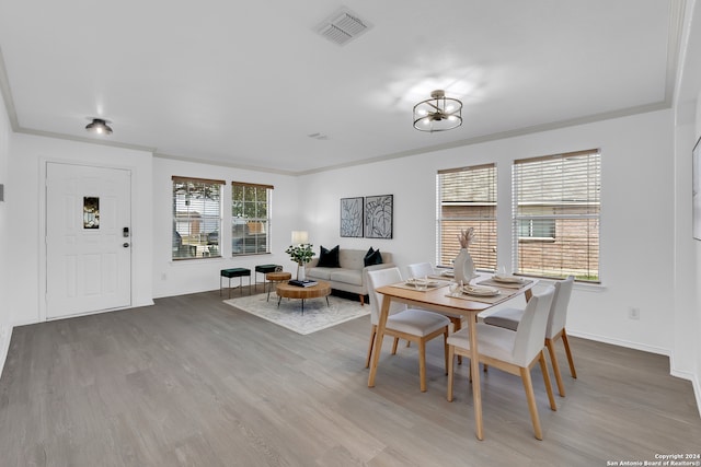 dining space featuring crown molding, hardwood / wood-style floors, and a chandelier