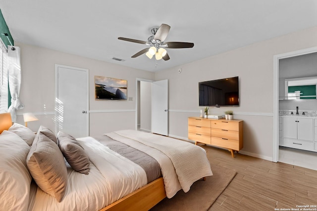 bedroom featuring ceiling fan, light hardwood / wood-style flooring, and ensuite bathroom