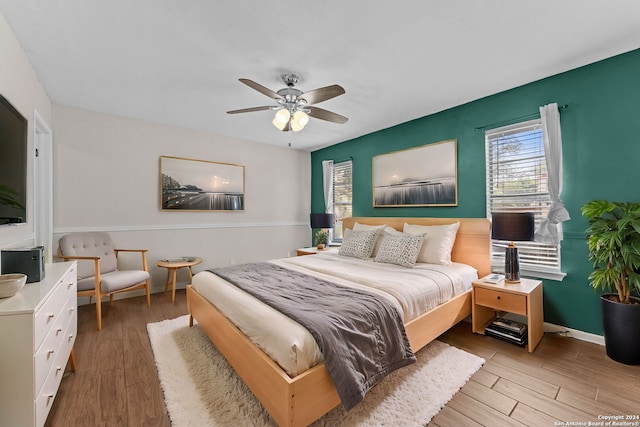 bedroom with light hardwood / wood-style floors and ceiling fan