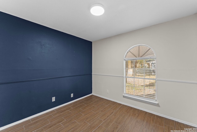 spare room featuring wood-type flooring