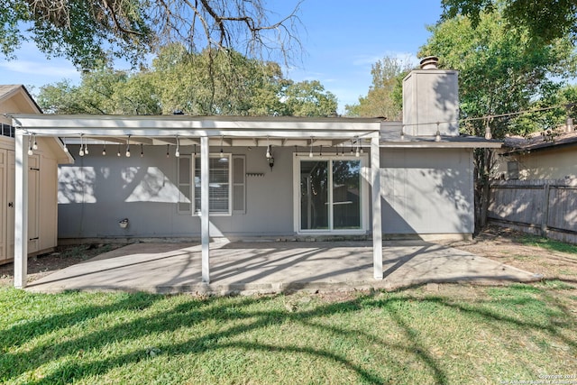 rear view of property featuring a yard and a patio