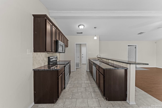 kitchen with appliances with stainless steel finishes, light wood-type flooring, dark stone counters, sink, and hanging light fixtures