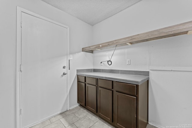 laundry room with light tile patterned floors and a textured ceiling