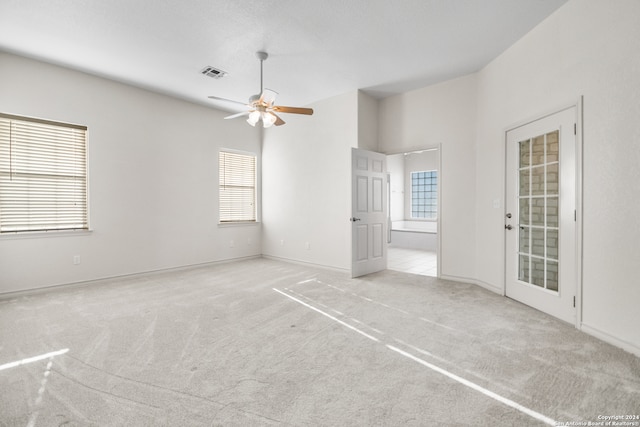 interior space featuring light carpet, access to outside, and ceiling fan