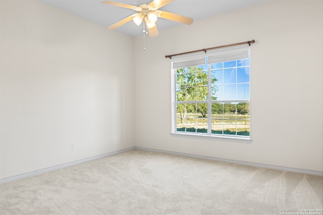 carpeted spare room featuring ceiling fan