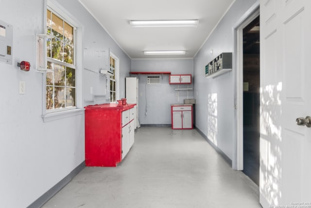 corridor featuring a wall unit AC and a healthy amount of sunlight