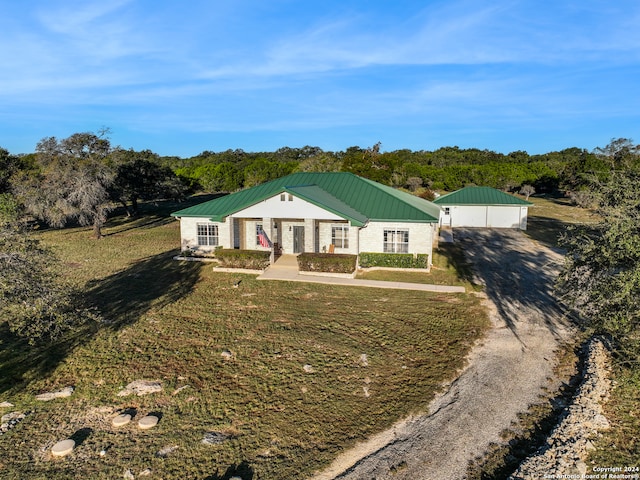 view of front facade featuring a garage, an outbuilding, and a front yard