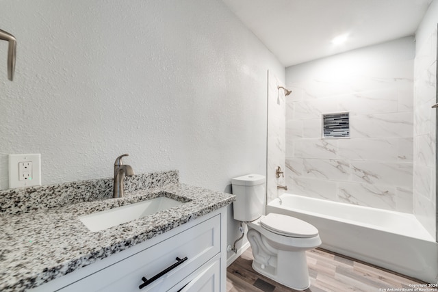 full bathroom with vanity, toilet, wood-type flooring, and tiled shower / bath