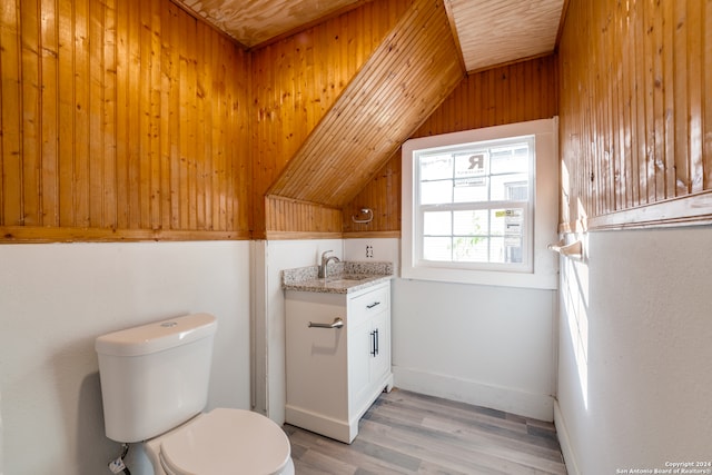 bathroom featuring hardwood / wood-style flooring, vaulted ceiling, wooden walls, and wood ceiling