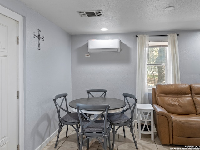 tiled dining room with an AC wall unit and a textured ceiling