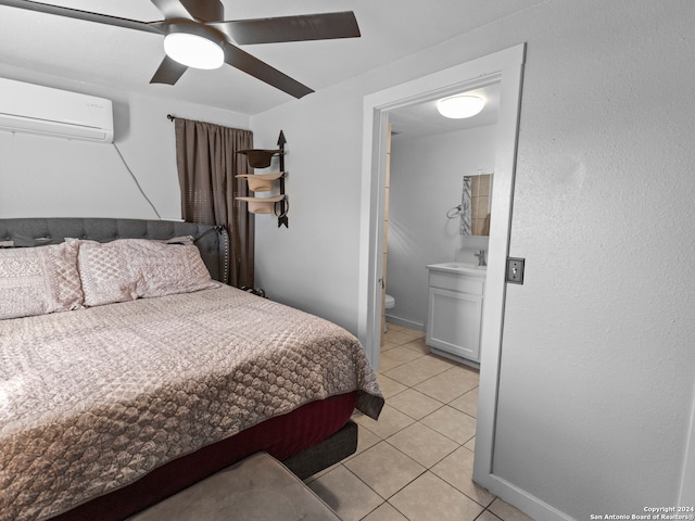 bedroom featuring connected bathroom, ceiling fan, sink, a wall unit AC, and light tile patterned flooring