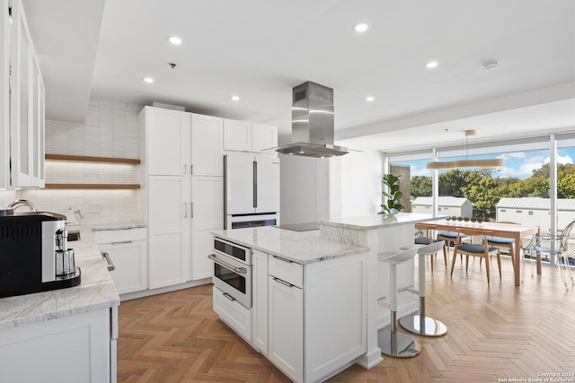 kitchen with white appliances, white cabinetry, island range hood, and open shelves