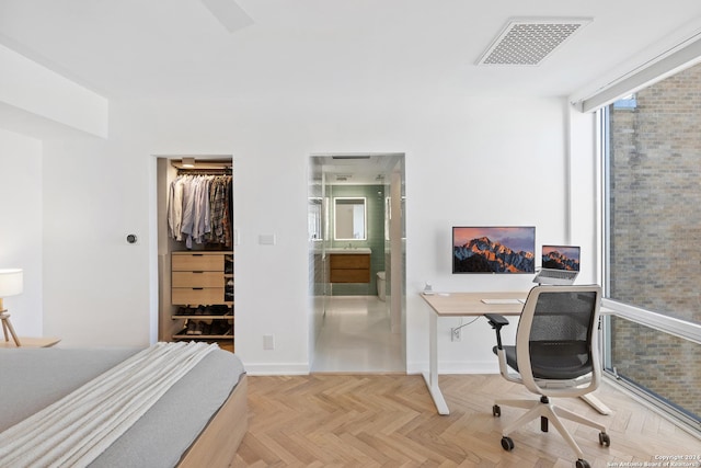 bedroom with a closet, visible vents, a spacious closet, connected bathroom, and baseboards