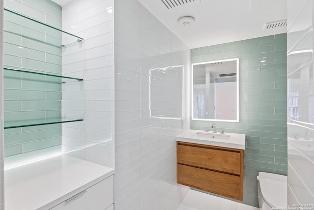 full bath with toilet, visible vents, vanity, tile walls, and a shower