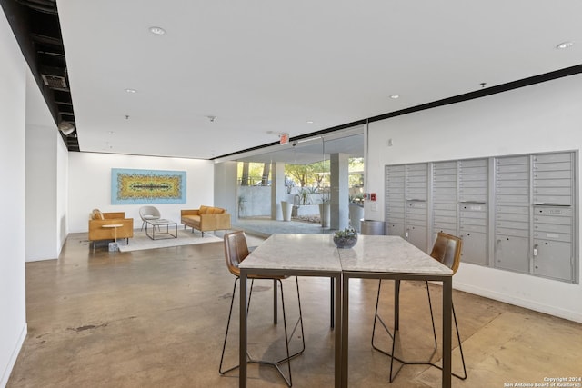 dining space featuring expansive windows, concrete floors, mail area, and recessed lighting