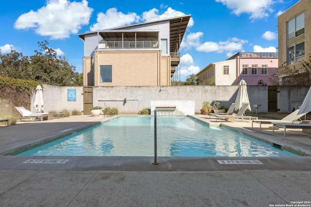 community pool with fence and a patio