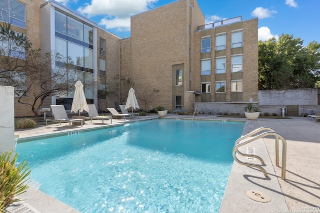 community pool with a patio and fence