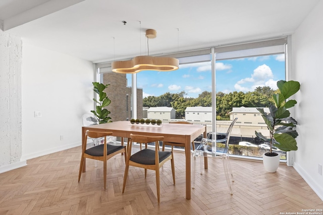 dining space featuring baseboards and a wall of windows